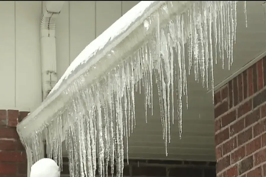 Frozen water and icicles along a roof edge